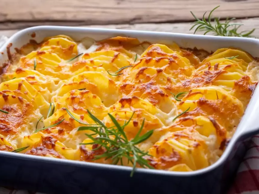 Gratin de patate douce doré et croustillant servi dans un plat en terre cuite