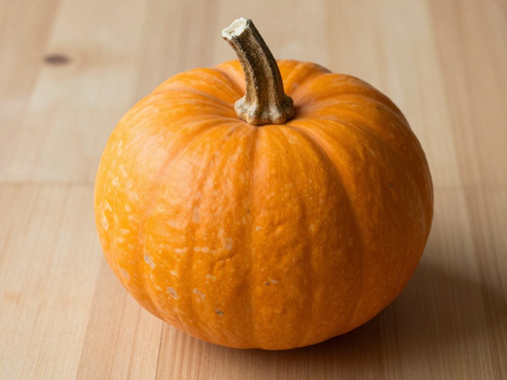 Potimarron entier avec sa peau orange caractéristique en forme de toupie